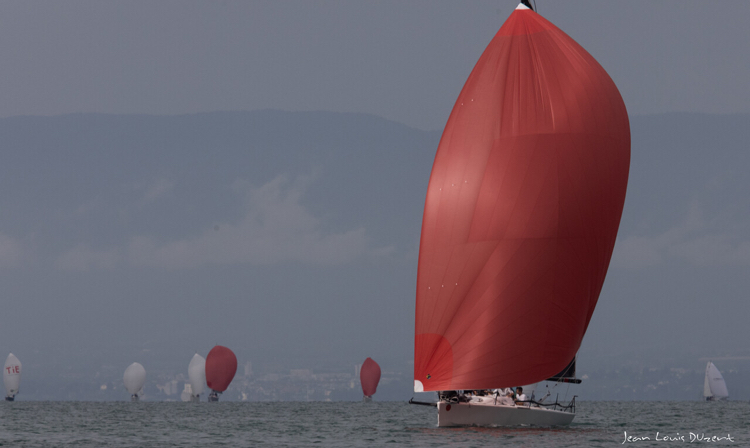 L'équipage sous sppi navigue vers la victoire au X de Sciez 2023. Sailing Objectives en action réglages des voiles spi rouge voilier blanc