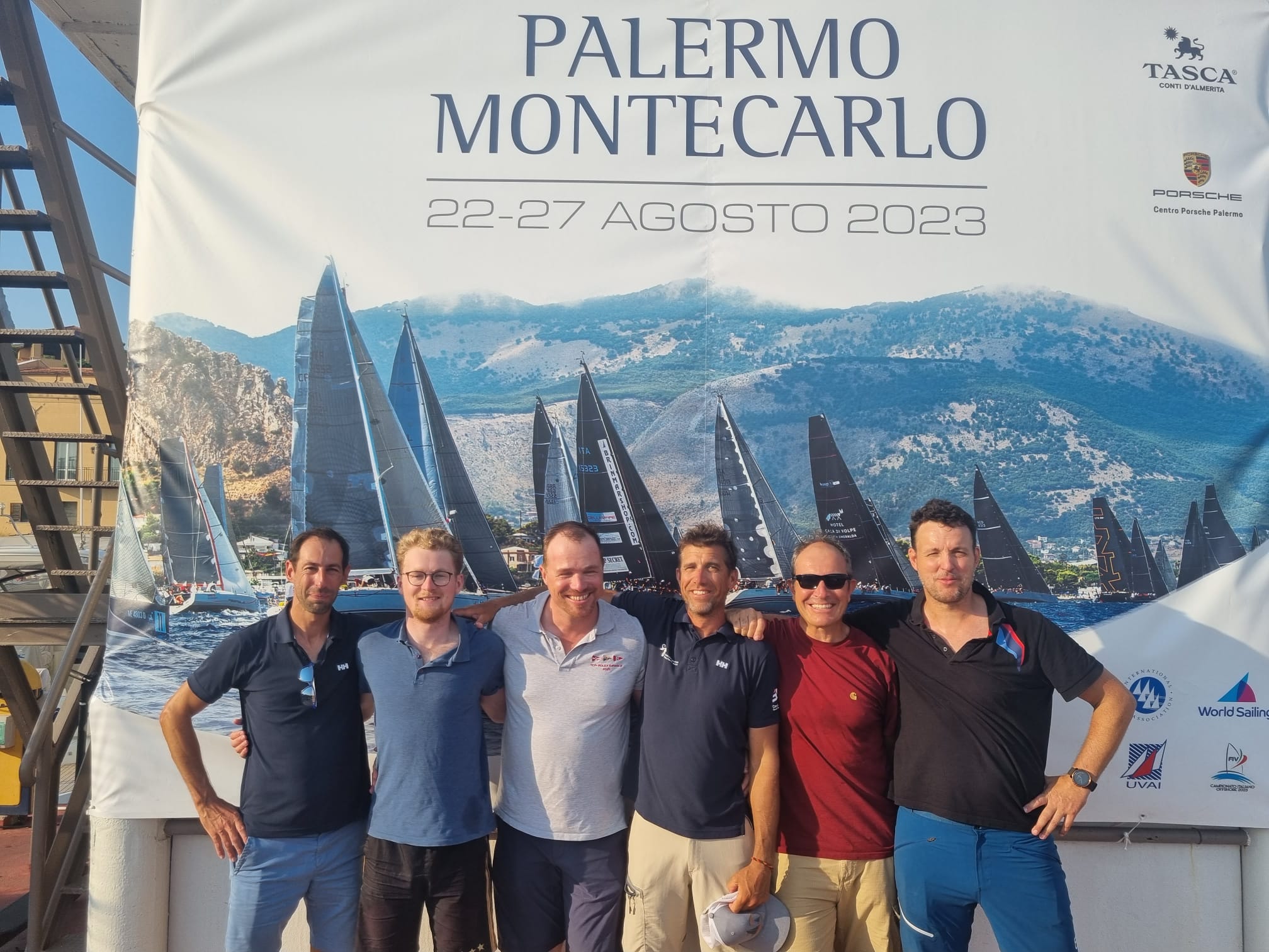 Equipage Palermo Monaco L'équipage SailO pour la Palermo Monaco en 2023 devant l'affiche avant le départ