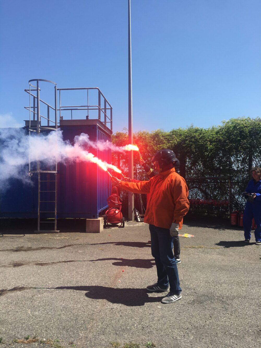 Un marin tient une fusée de détresse rouge déclenchée en stage survie